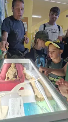 Profesor pokazuje czaszkę kopalnego gada.