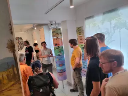 Zwiedzanie wystawy przez paleontologów. Słuchają oprowadzającego.