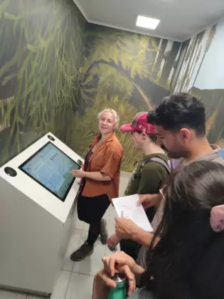 Naukowcy stojący przed zabawką dźwiękonaśladowczą.